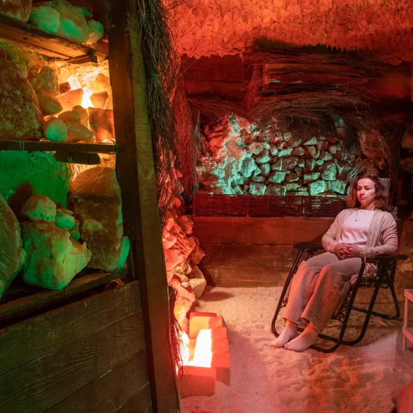 Žena odpočívající na lehátku v solné jeskyni po masáži, v uklidňujícím světle a přírodním solném prostředí