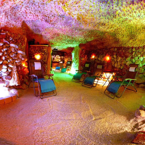 Interior of a salt cave with natural salt walls and relaxing lounge chairs